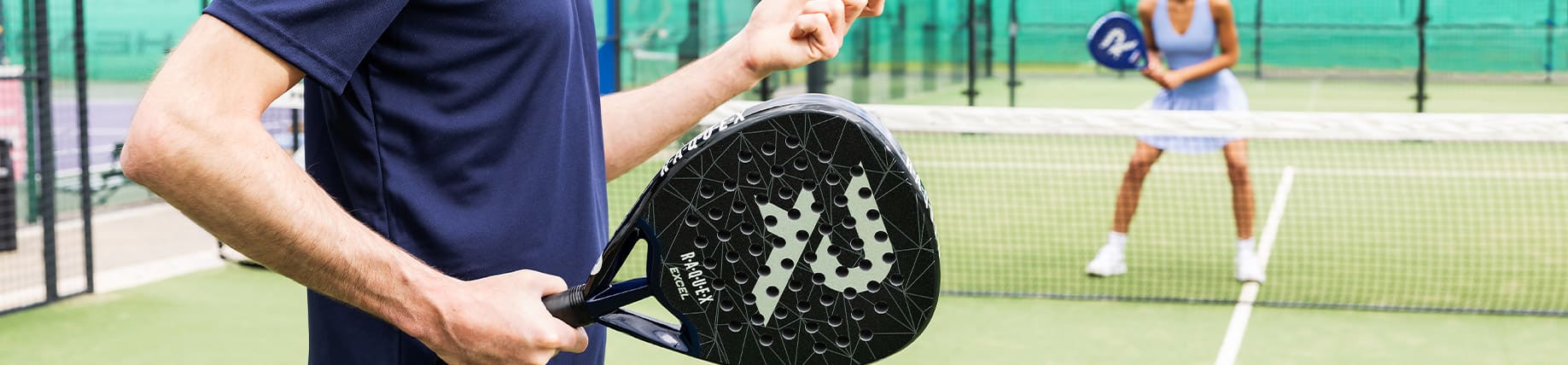 A person about to serve with his raquex padel racket