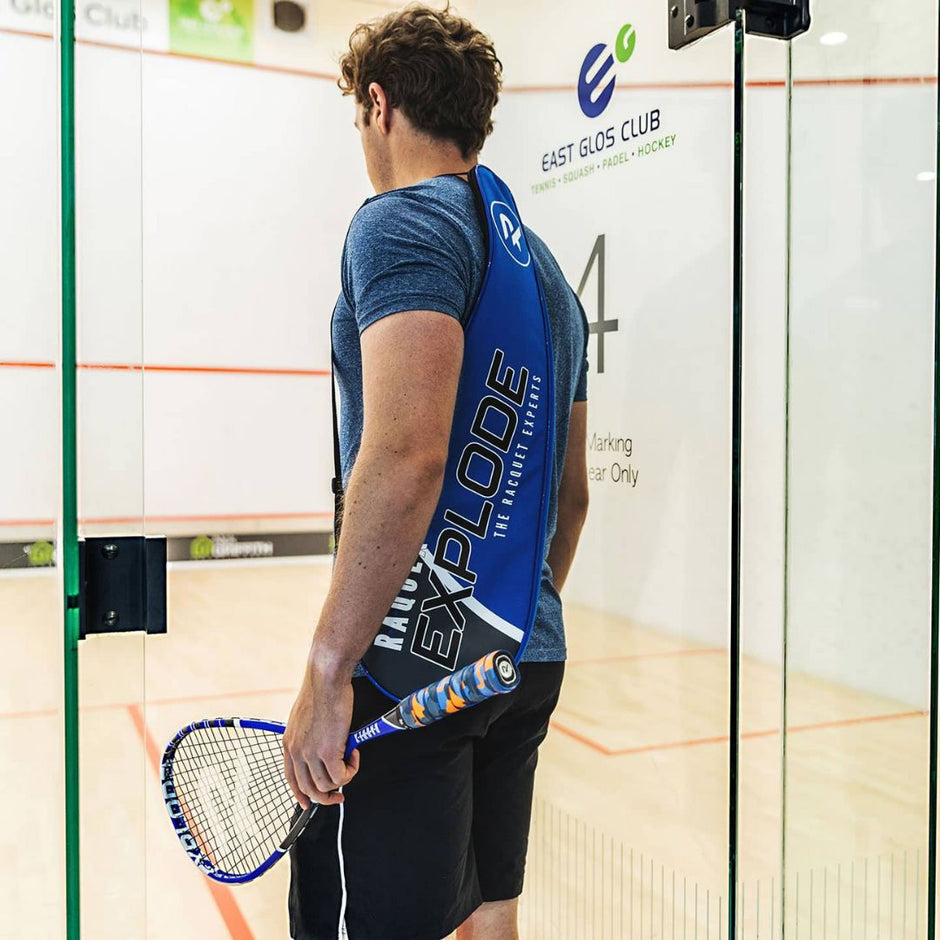 A man entering a squash court wearing Raquex gear