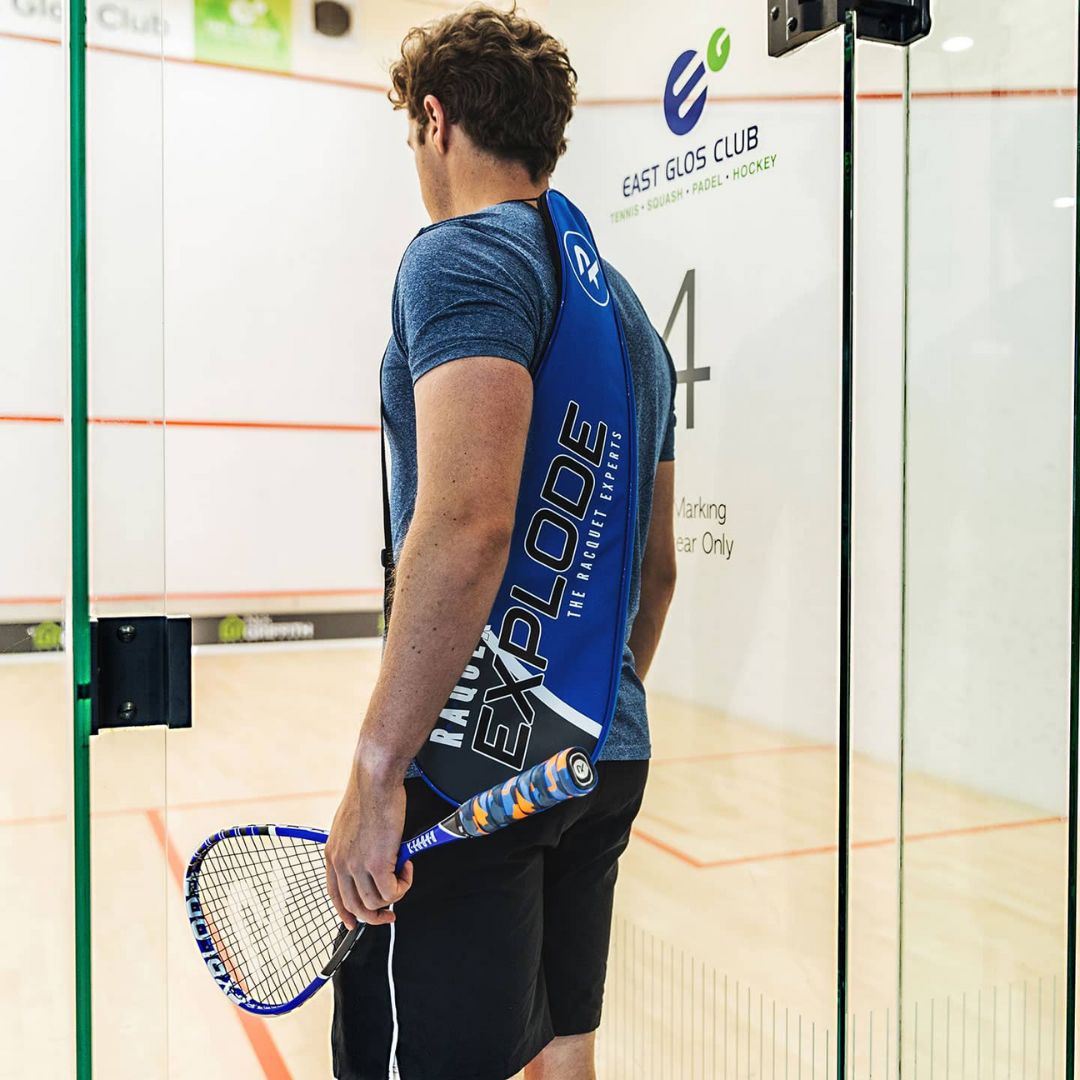 A man entering a squash court wearing Raquex gear
