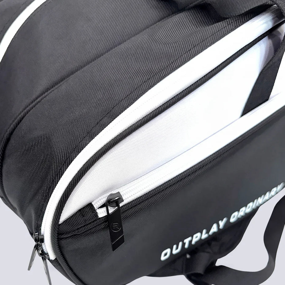 Open racquet compartment on the Raquex Elevate Tour bag showing the white lining and branded zip pull