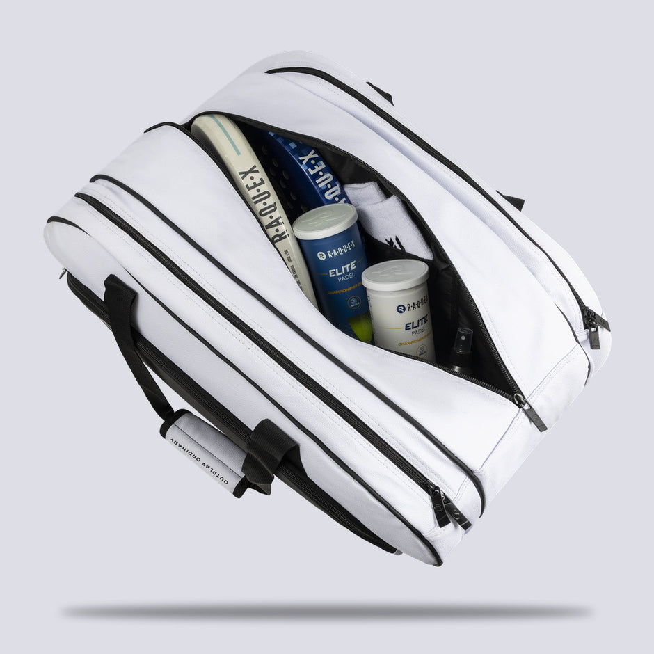 Central compartment of the white Raquex Execute Tour padel bag loaded with racquets, ball tubes and kit