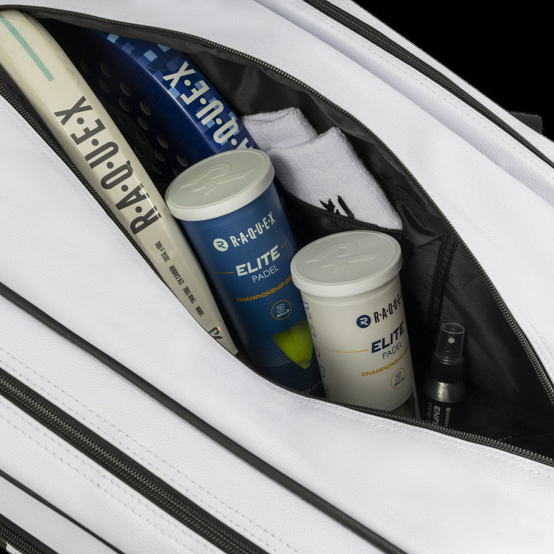 Close-up inside the white Raquex Execute Tour padel bag with padel racquets and Raquex Elite ball tubes