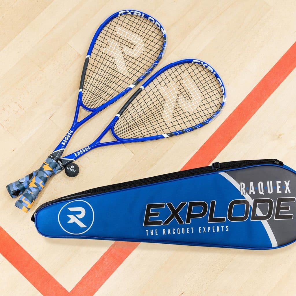 Two blue squash racquets with blue and orange camo racquet grips, a blue racquet bag and black ball