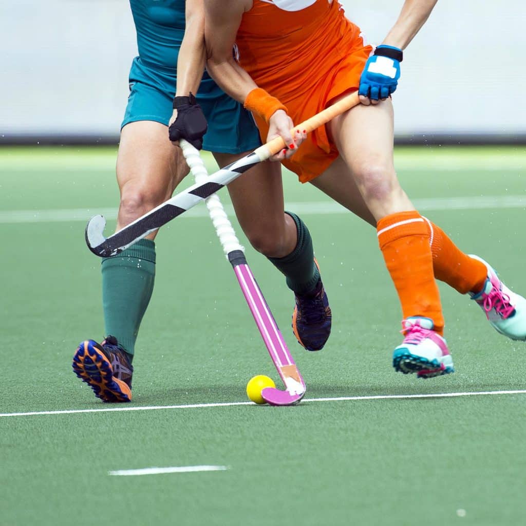 an action shot of two players playing hockey with the Raquex hockey grips installed on their hockey sticks