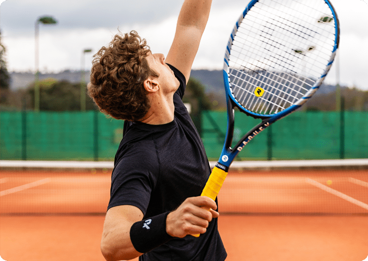 Image of a man with a tennis racket, using racquet or hockey grip tape